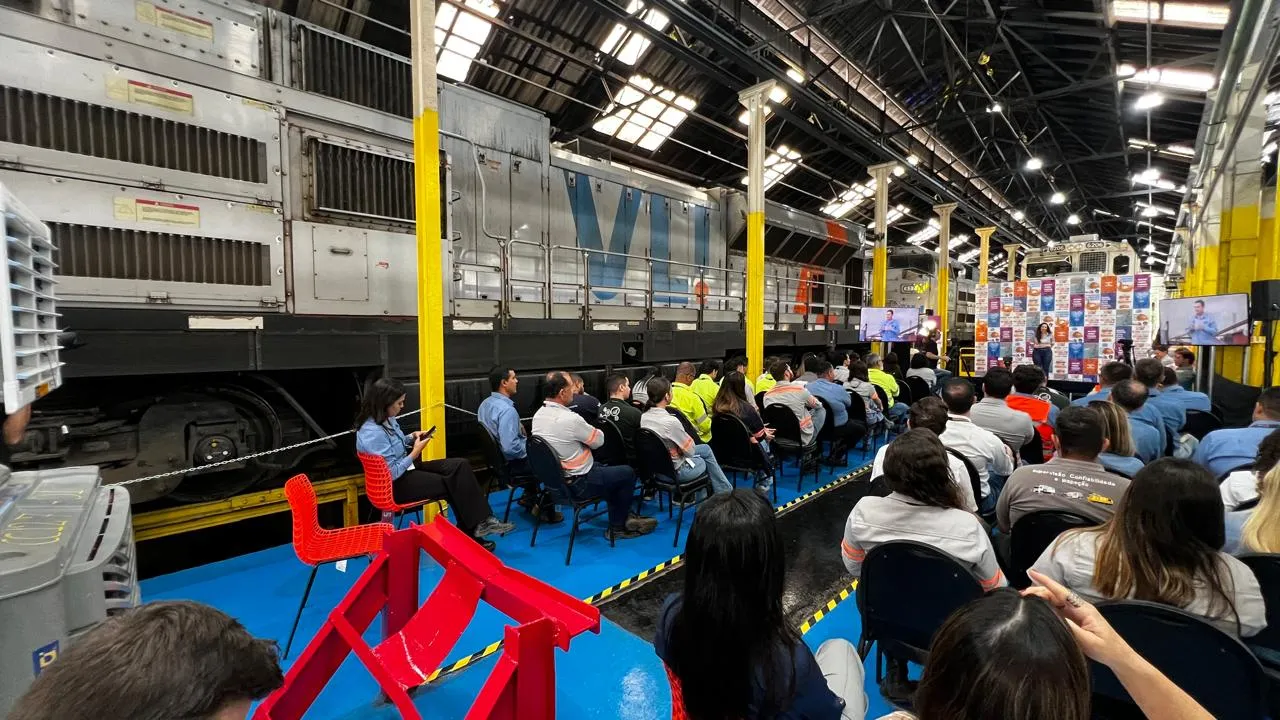 Plateia reunida em evento corporativo dentro de um galpão industrial